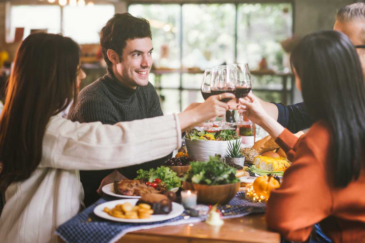 Tavolo apparecchiato all’aperto in riva al lago a Limone sul Garda, con piatti tipici locali, limoni freschi e vista sulle montagne